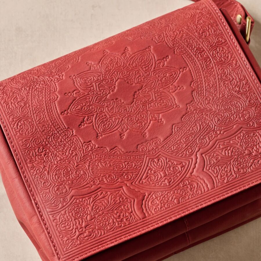 10 Best Fair Trade Handbags for 2026 3 Close-up of a red leather crossbody bag featuring intricate designs, showcasing its craftsmanship and vibrant color.