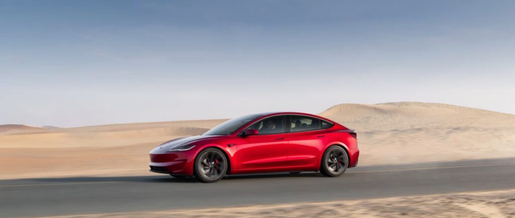 10 Most Eco-Friendly Cars for Different Lifestyles in 2026 19 Red Tesla Model 3 Standard RWD parked in a desert landscape under a clear blue sky.