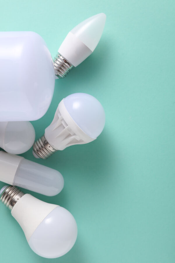 Do Energy-Efficient Light Bulbs Give Off Radiation? 4 Different styles of LED light bulbs arranged on a mint green surface.